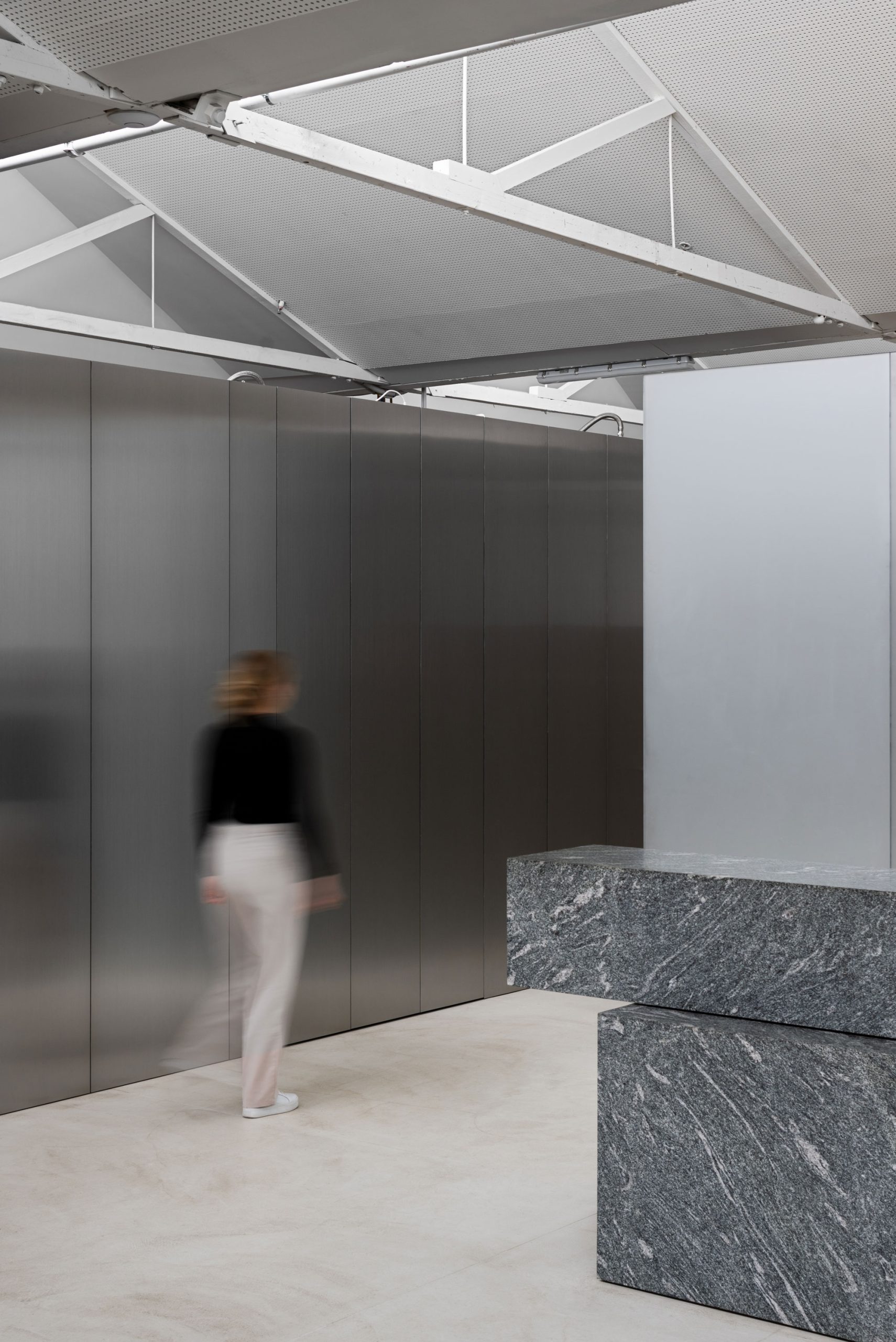 Person walking along a corridor of steel laminate joinery in the Cera Stribley Melbourne Studio