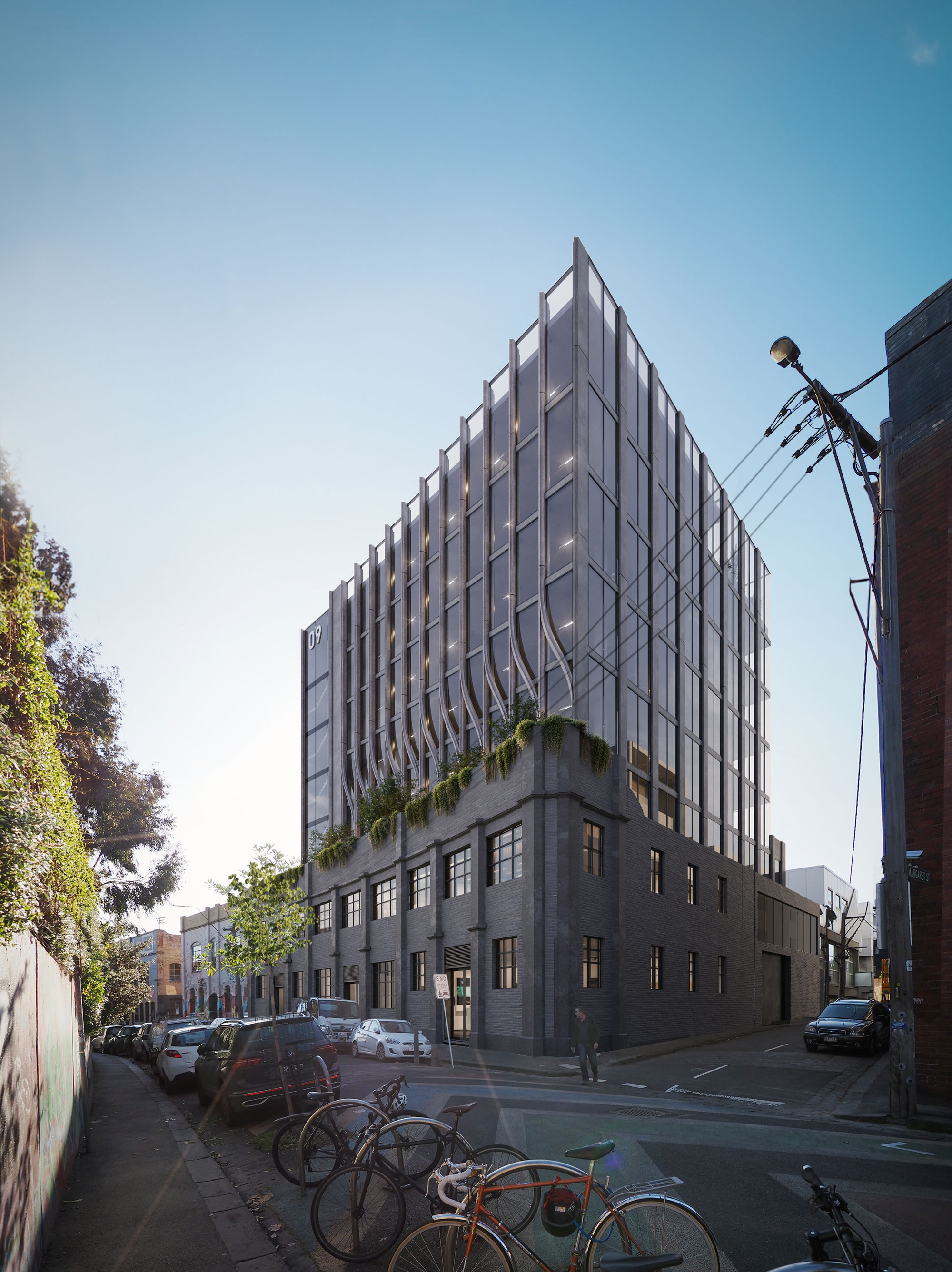 Corner view of industrial architectural building with modern addition, curved concrete detailing and glass windows.