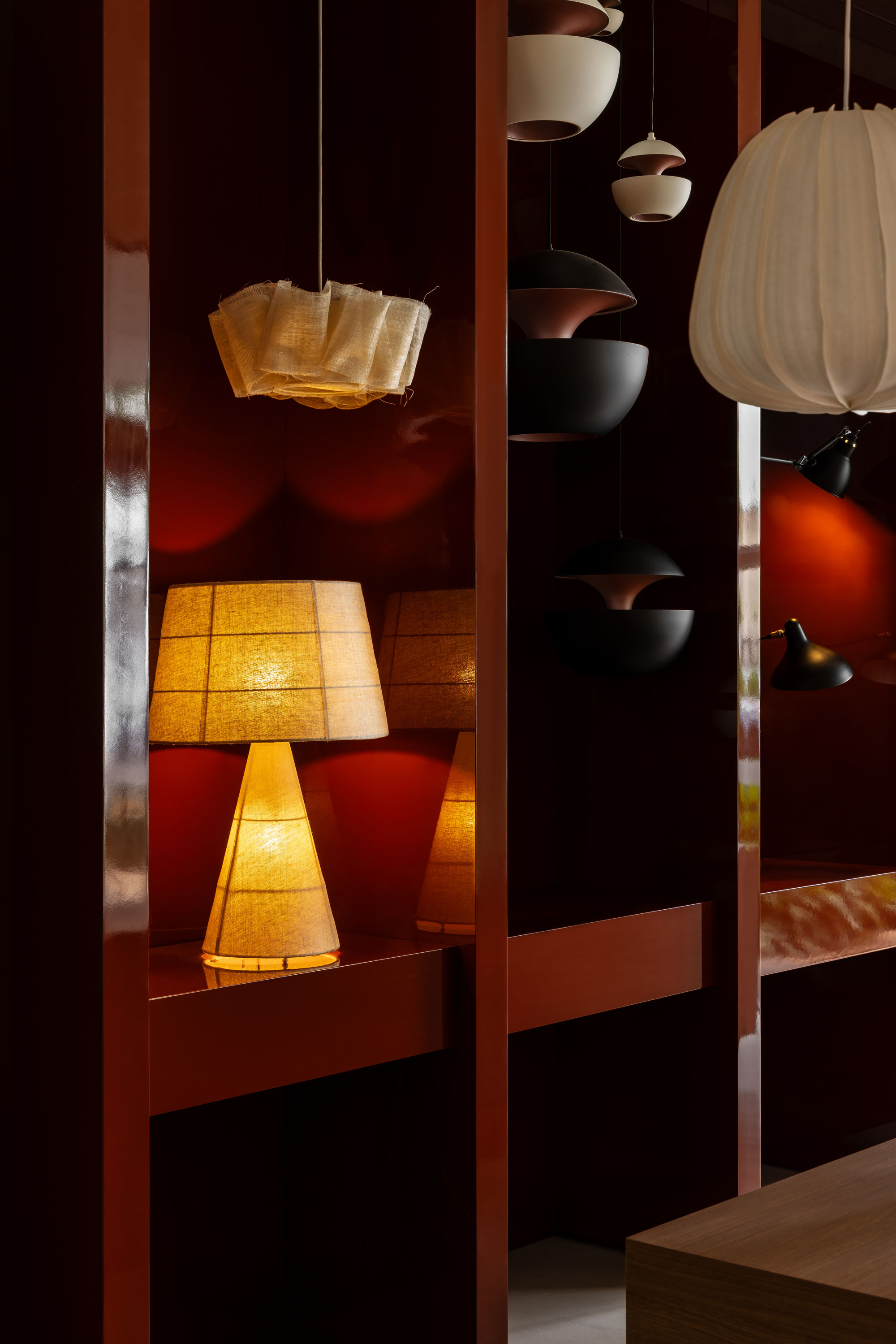 Close up image of shelving with eclectic collection of lighting in a rust coloured laminate cabinet.