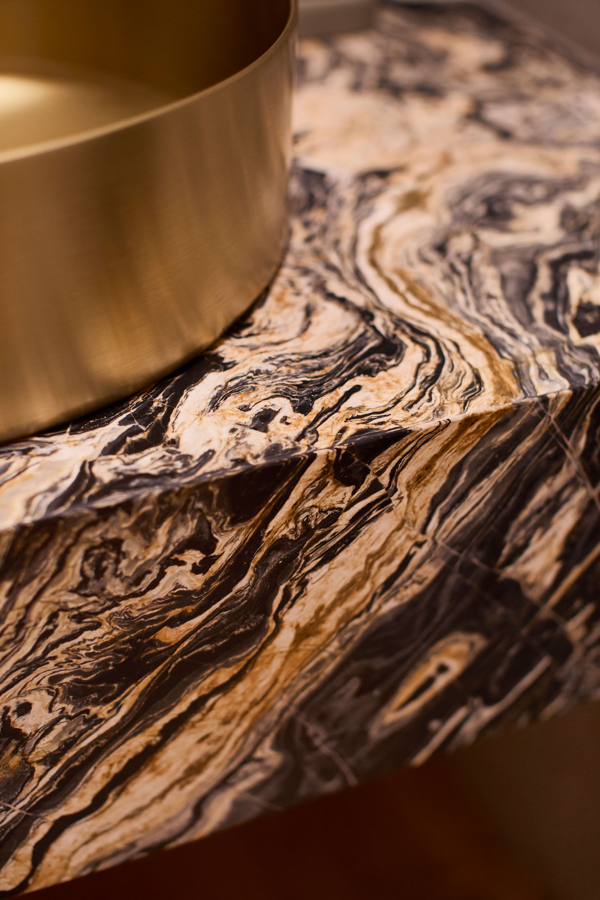 Vignette of marble bench top and brass basin.