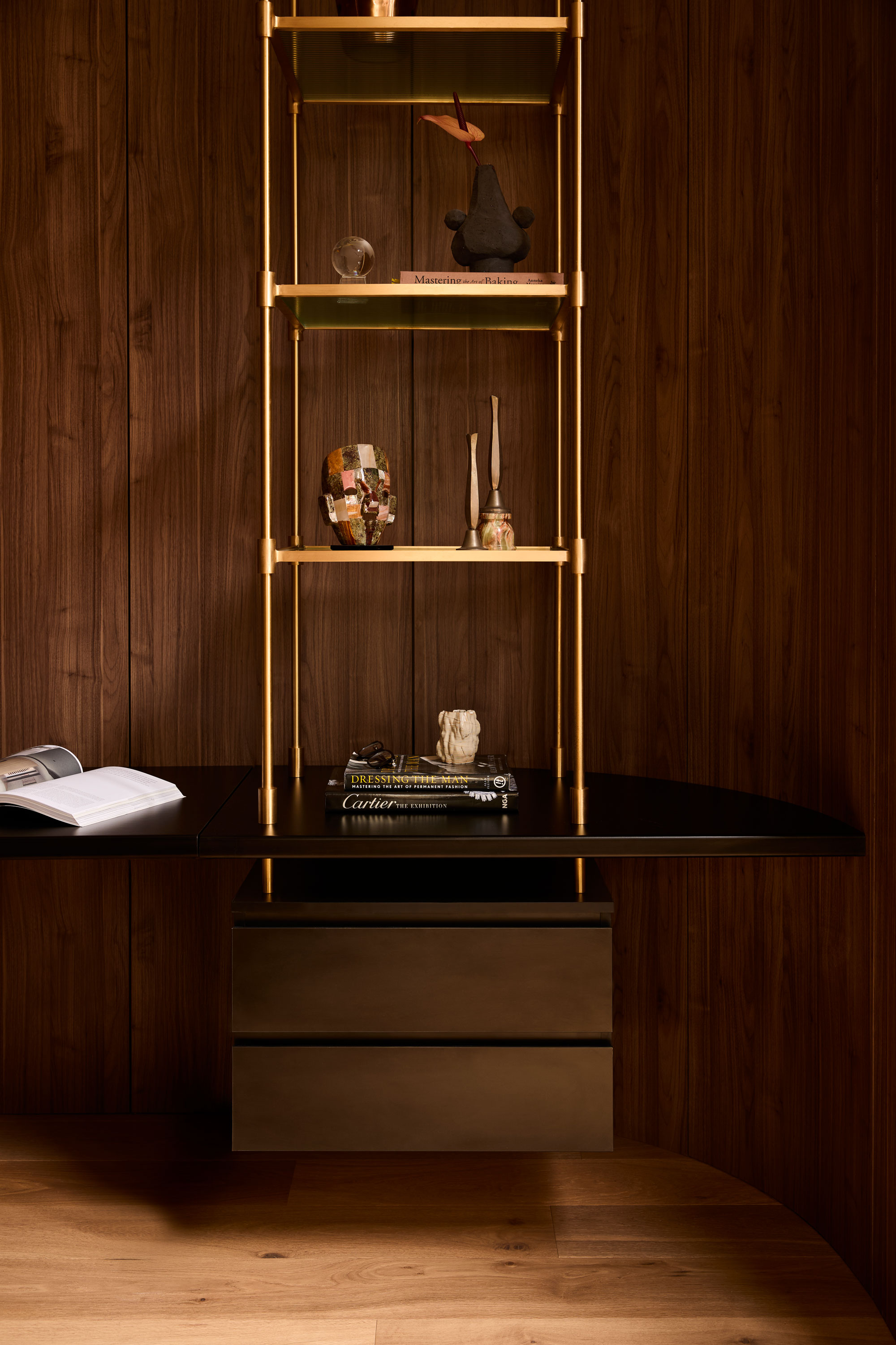Modern study space with dark timber panelling, black joinery and brass open shelving.